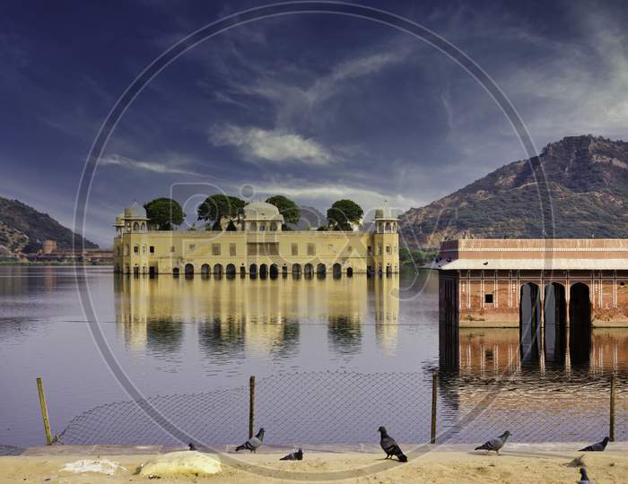 Wide Angle Shot Of Jal Mahal (Water Palace) Against Blue Sky Located In Jaipur City Of Rajasthan State, India