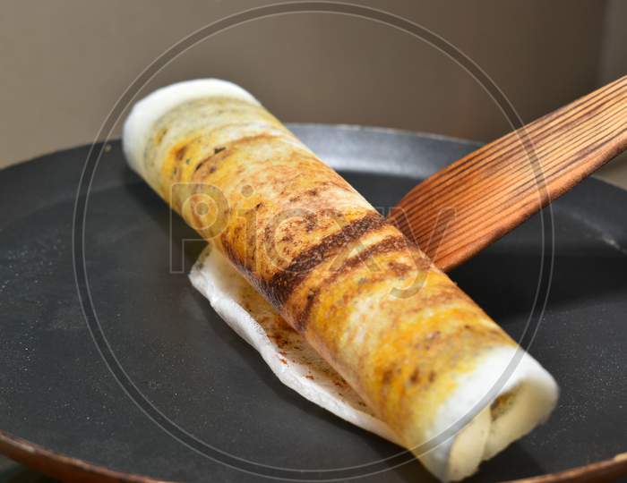 Rolling The Dosa On Hot Non Stick Tawa With Wooden Spatula