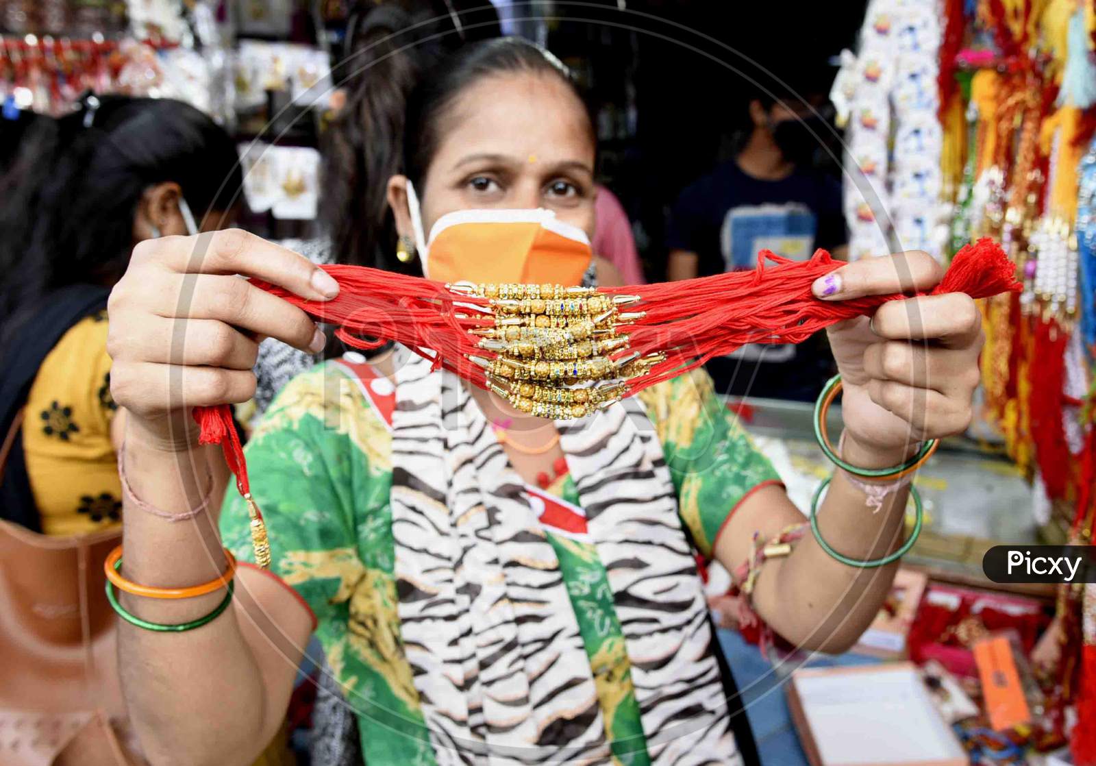 A woman shows 'rakhi' after purchasing, ahead of Raksha Bandhan festival, in Guwahati on July 30, 2020.