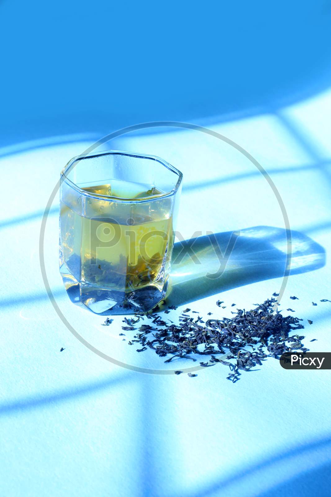 Green Tea In A Glass With Morning Sun Rays On Blue Isolated Background