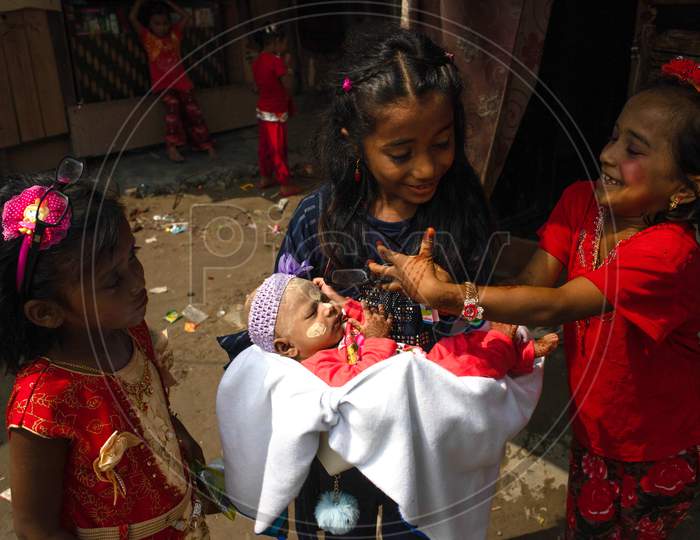 Rohingya refugee girls hold an infant child painted with traditional Myanmar make up during Eid-Al-Adha (Feast of Sacrifice) festival at a camp in the outskirts of New Delhi, India on August 1, 2020