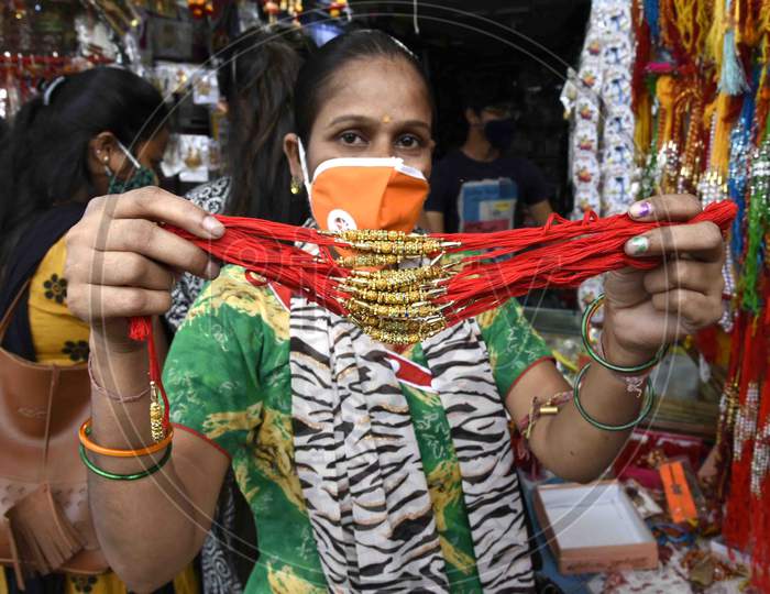A woman shows 'Rakhi' after purchasing, ahead of Raksha Bandhan festival, in Guwahati on July 30, 2020.