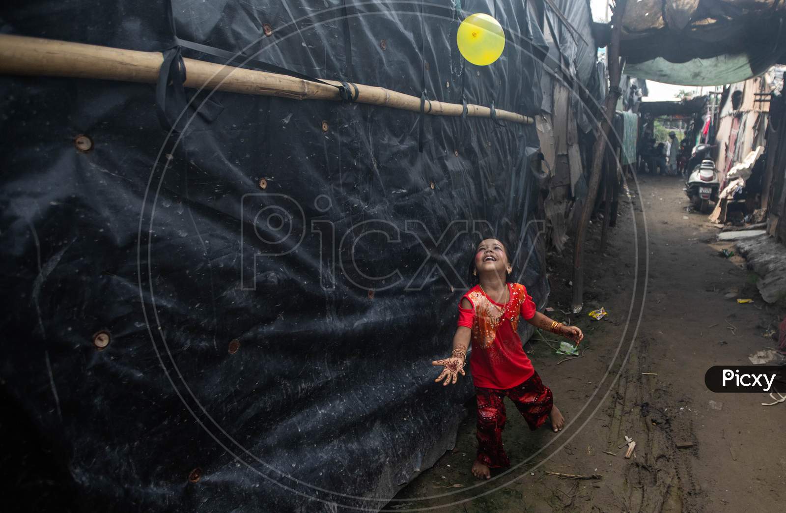 A Rohingya refugee girl plays as she wears new clothes and make up during Eid Al-Adha (Feast of Sacrifice) festival at a camp in the outskirts of New Delhi, India on August 1, 2020.