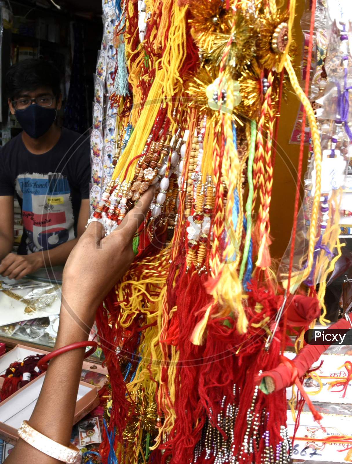 A woman purchases 'Rakhi' ahead of Raksha Bandhan festival in Guwahati on July 30, 2020.