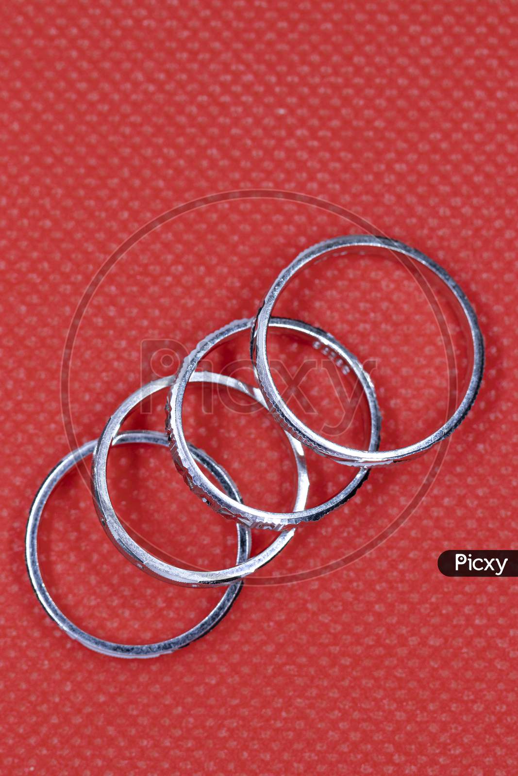 Silver Four Round Rings On Red Background