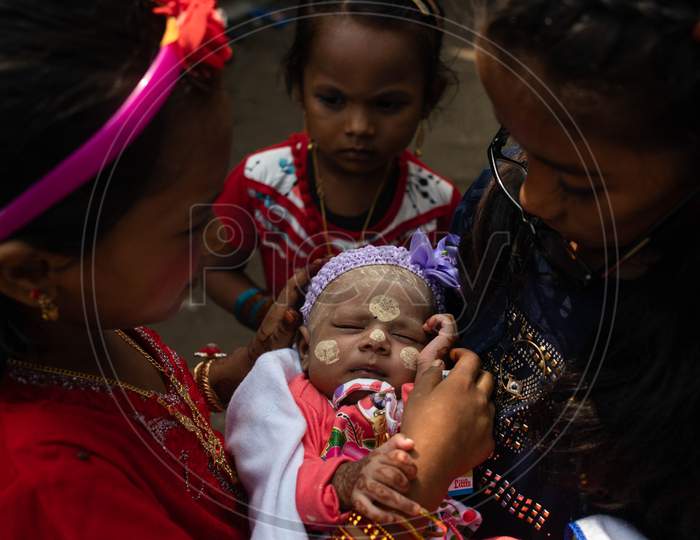 Rohingya refugee girls hold an infant child painted with traditional Myanmar make up during Eid-Al-Adha (Feast of Sacrifice) festival at a camp in the outskirts of New Delhi, India on August 1, 2020.