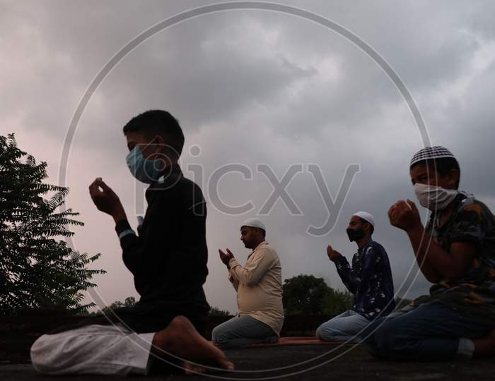 Muslims offer prayers at a roof of a house during Eid al-Adha festival as authorities imposed weekend lockdown in Jammu on August 1, 2020.