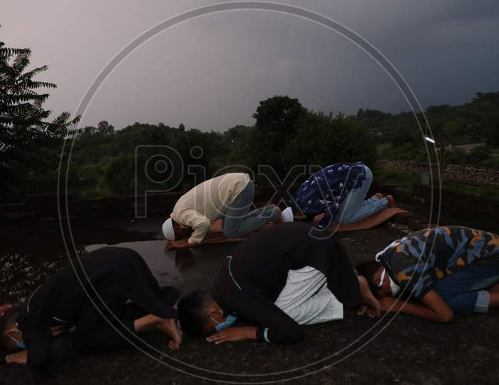 Muslims offer prayers at a roof of a house during Eid al-Adha festival as authorities imposed weekend lockdown in Jammu on August 1, 2020.