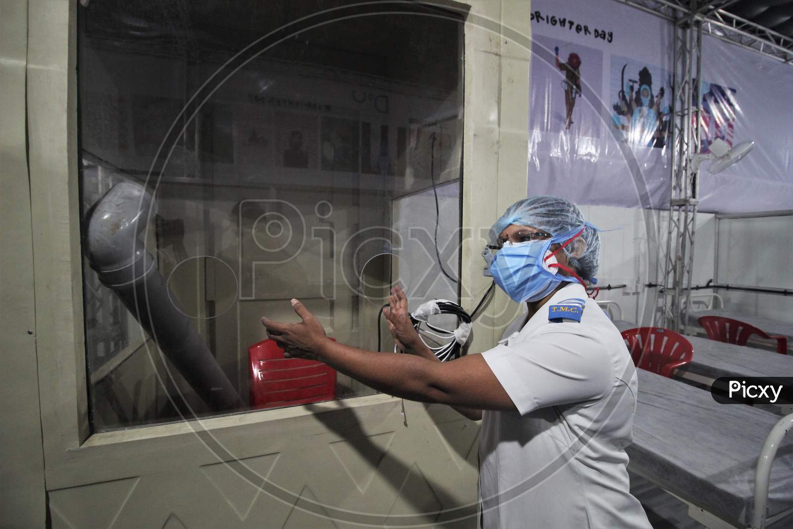 A nurse shows the swab test booth inside the newly inaugurated temporary facility created to screen cancer patients for covid 19, in Mumbai, India on July 30, 2020.