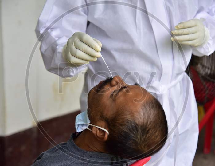 A Health Worker Takes A Nasal Swab Sample To Test For Covid-19  At Barhampur Village In Nagaon District Of Assam On August 8,2020.
