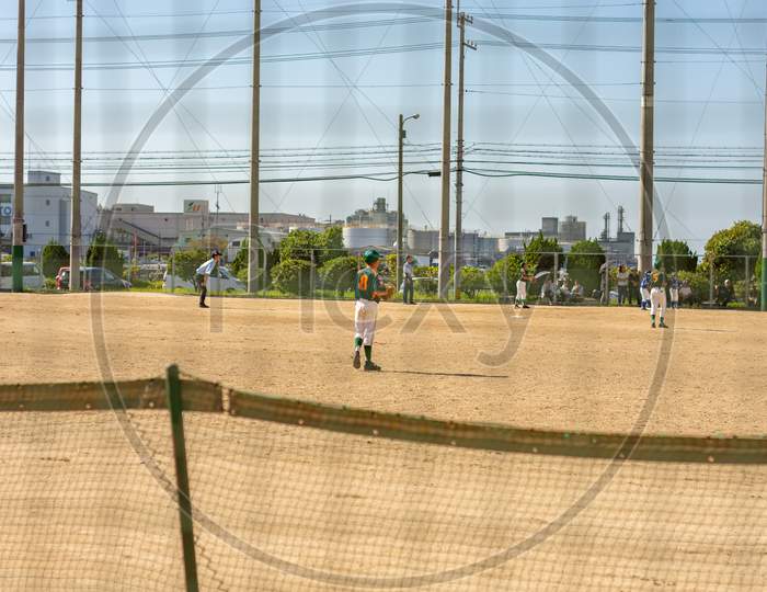 Children Playing Baseball In The Schoolyard In Osaka, Japan