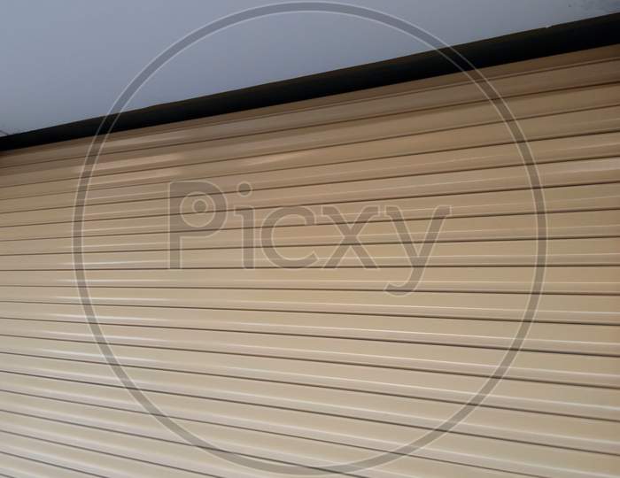 Beige Color Enamel Oil Painted Automatic Mechanic Steel Rolling Shutter Fixed For A Garage Of Car Parking Area Of An Residential Building Architectural Works