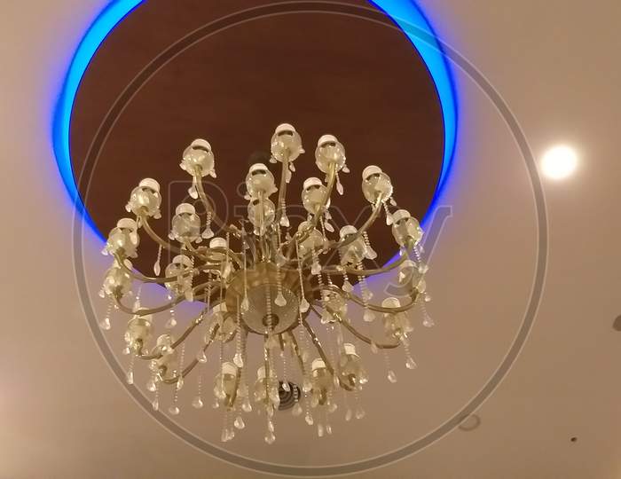 The Gypsum False Ceiling With Circle Wooden Ceiling And Chandelier At The Middle In Very Beautifully Decorated For An Hotel Entrance In Welcoming Way