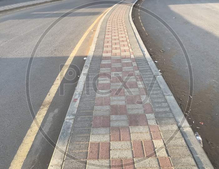 Pavement For Pedestrians In The Middle Of The Two Way Road Or Highways At Urban Or City Sides And Footpath Made Of Interlock Stones And Kerb Stones Precast