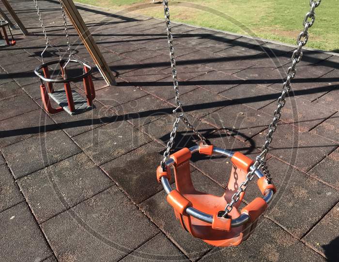 Orange Color Swing With Necessary Guard Ring For Children Playing In A Park For An Healthy Lifestyle In The Park Or Outdoor Area To Lead Healthy Life