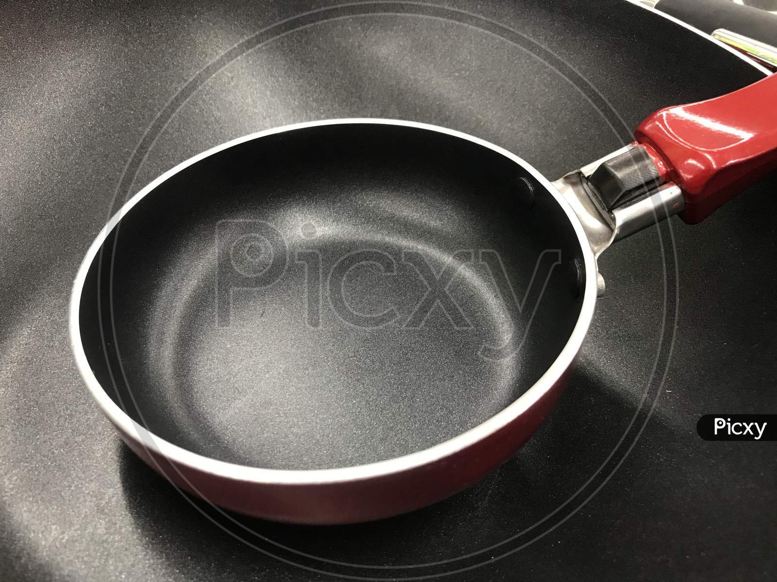 Red Color Handle Round Non Stick Cookware Placed In An Retail Shop In An Utensil And Food Division