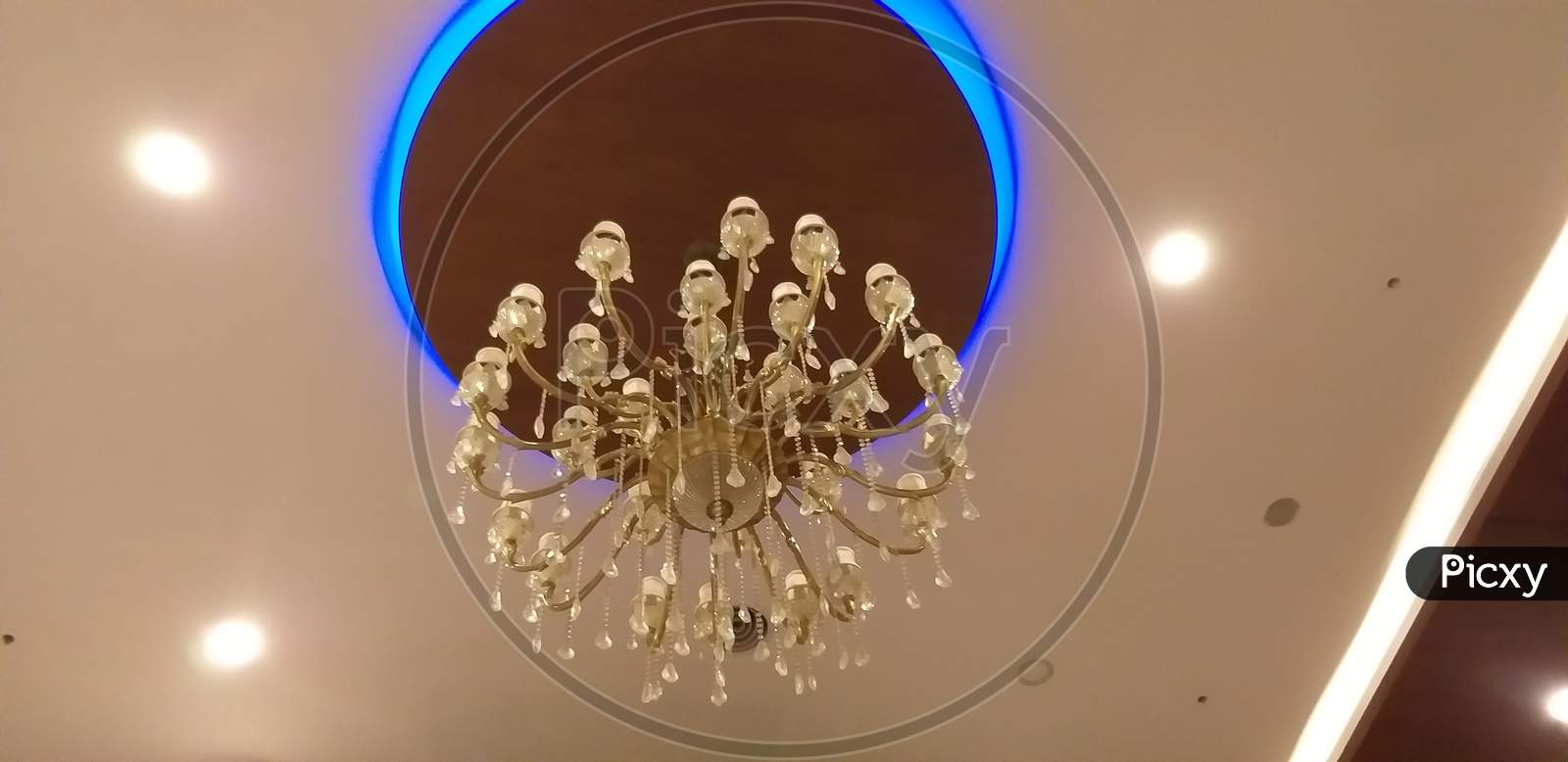 The Gypsum False Ceiling With Circle Wooden Ceiling And Chandelier At The Middle In Very Beautifully Decorated For An Hotel Entrance In Welcoming Way