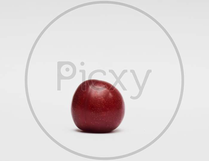 Single Plum Isolated On White Background. Close Up Of Single Fruit. Purple Red Maroon Cherry Plum