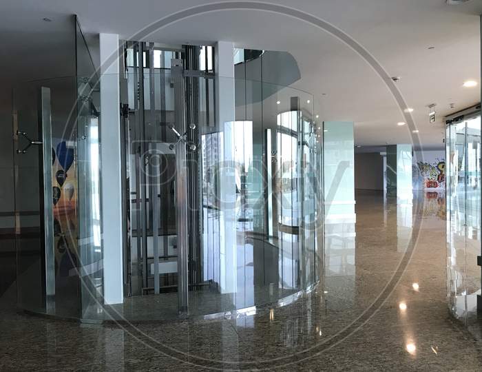 Passenger Lifts Or Elevators In Circular Shaped Covered By Toughened Glass Partition For Consumers Or User