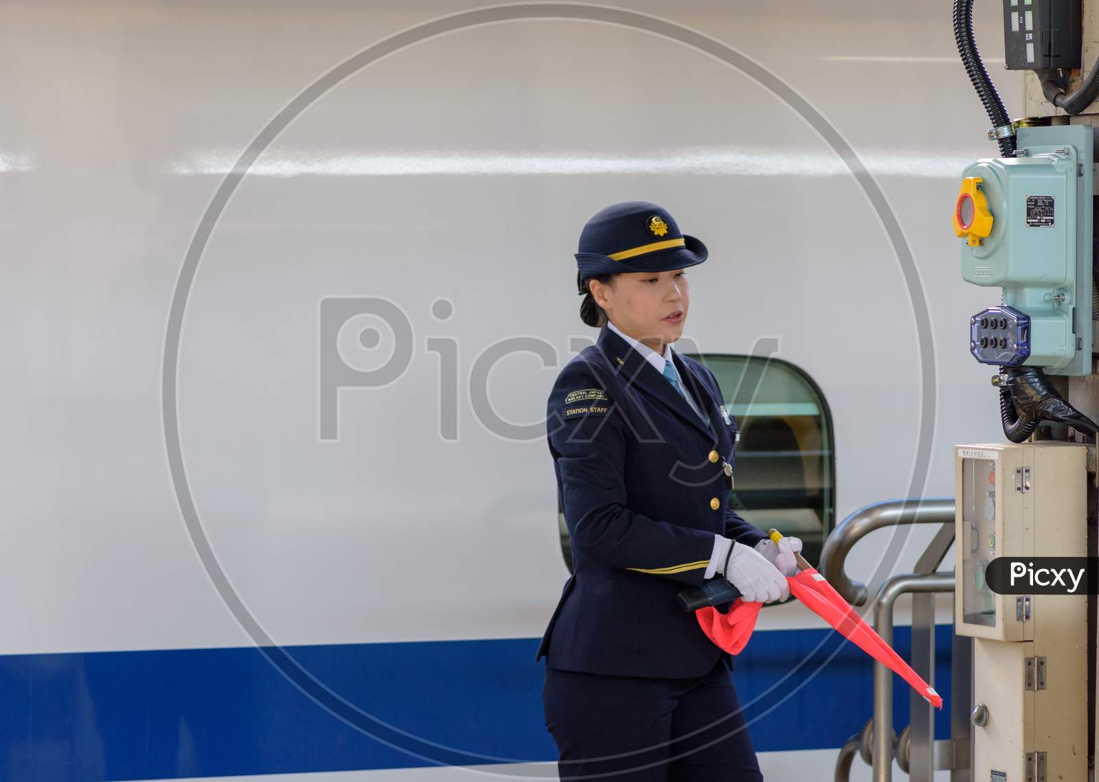 Osaka / Japan - December 20, 2017: Female Train Station Staff Officer Of Central Japan Railway Company In Front Of The Shinkansen Bullet Train At Shin-Osaka Railway Station In Osaka, Japan