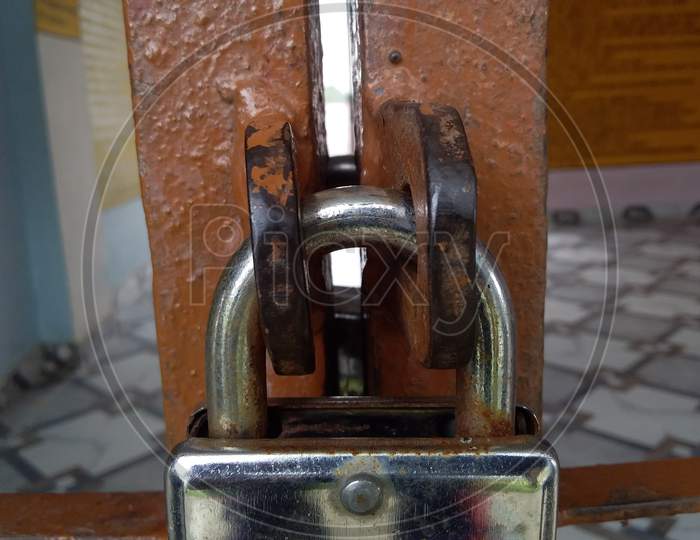 Iron bar gate locked with a padlock.