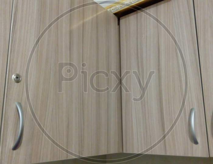 Laminate Finished Over Head Storage Cabinet With Stainless Steel Make Handle And Lock For An Kitchen Or Pantry Of An Residential Flat Or Office