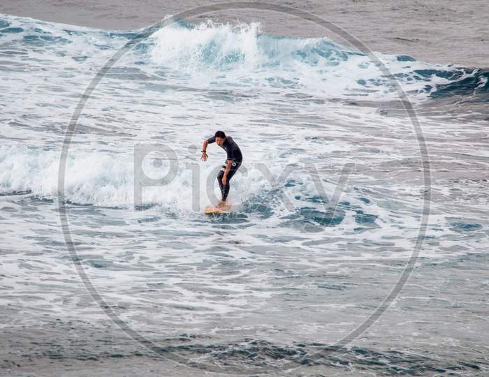 Surfer Riding The Waves In Okinawa Island Of Japan
