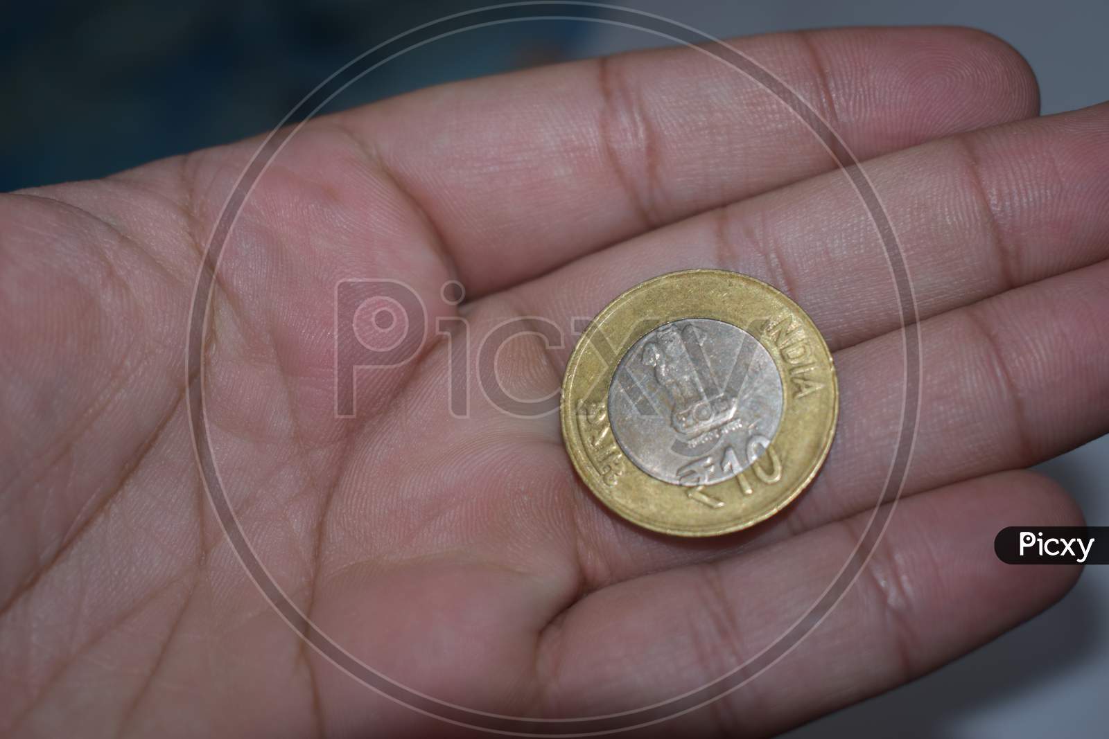Ten rupees coin in hand