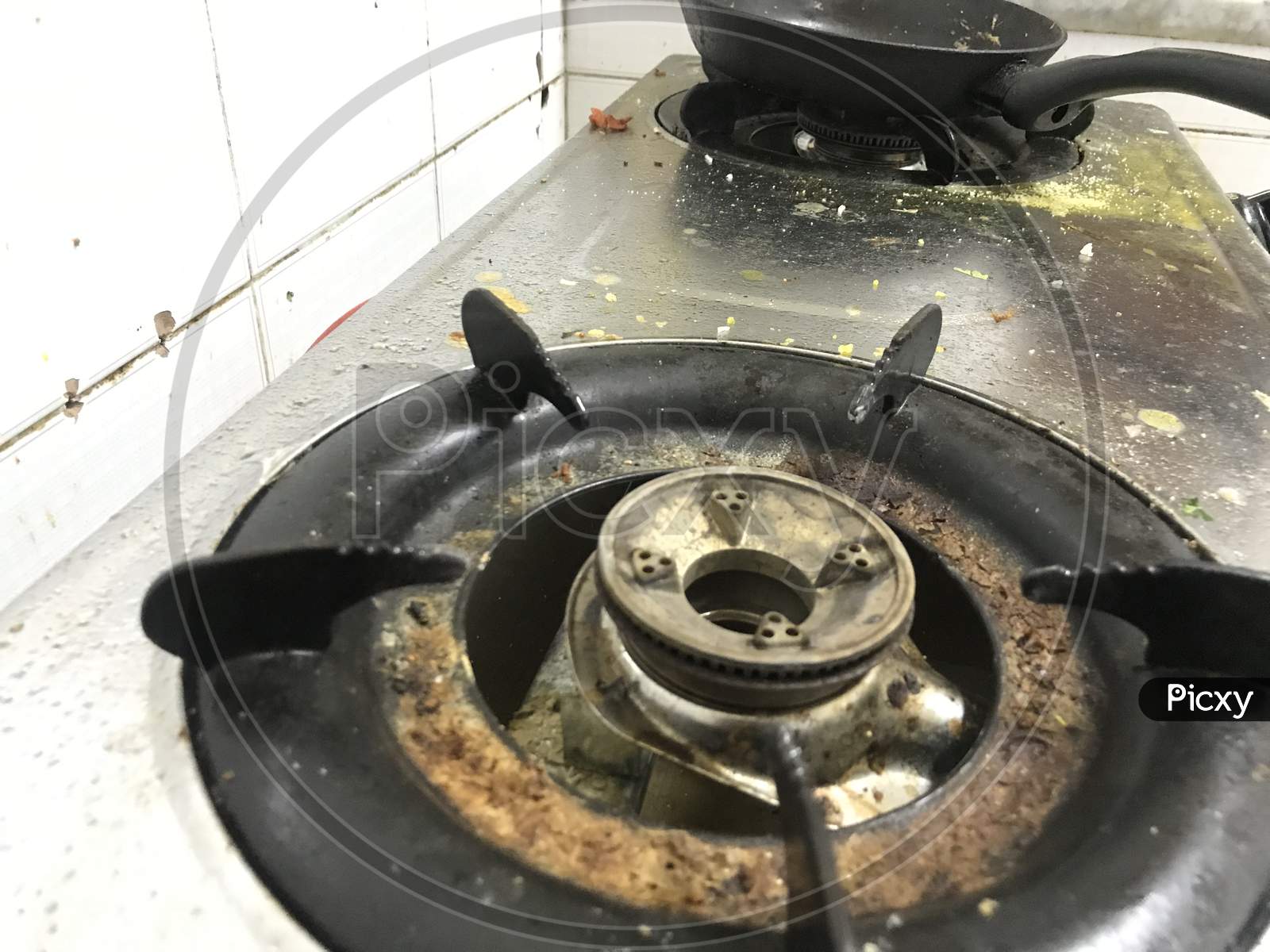 Uncleaned And Food Waste Scattered Over The Surface Of The Stainless Steel Finished Gas Stoves