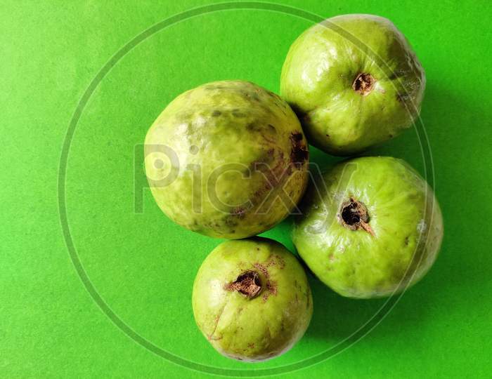 Four Fresh Guava Fruit Isolated On Green Background. Healthy Fruit