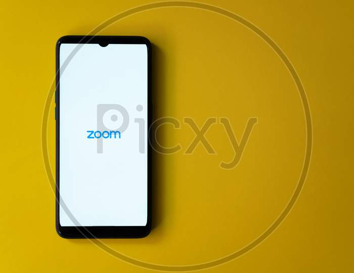 Zoom app home page on a smart phone against yellow background with copy space