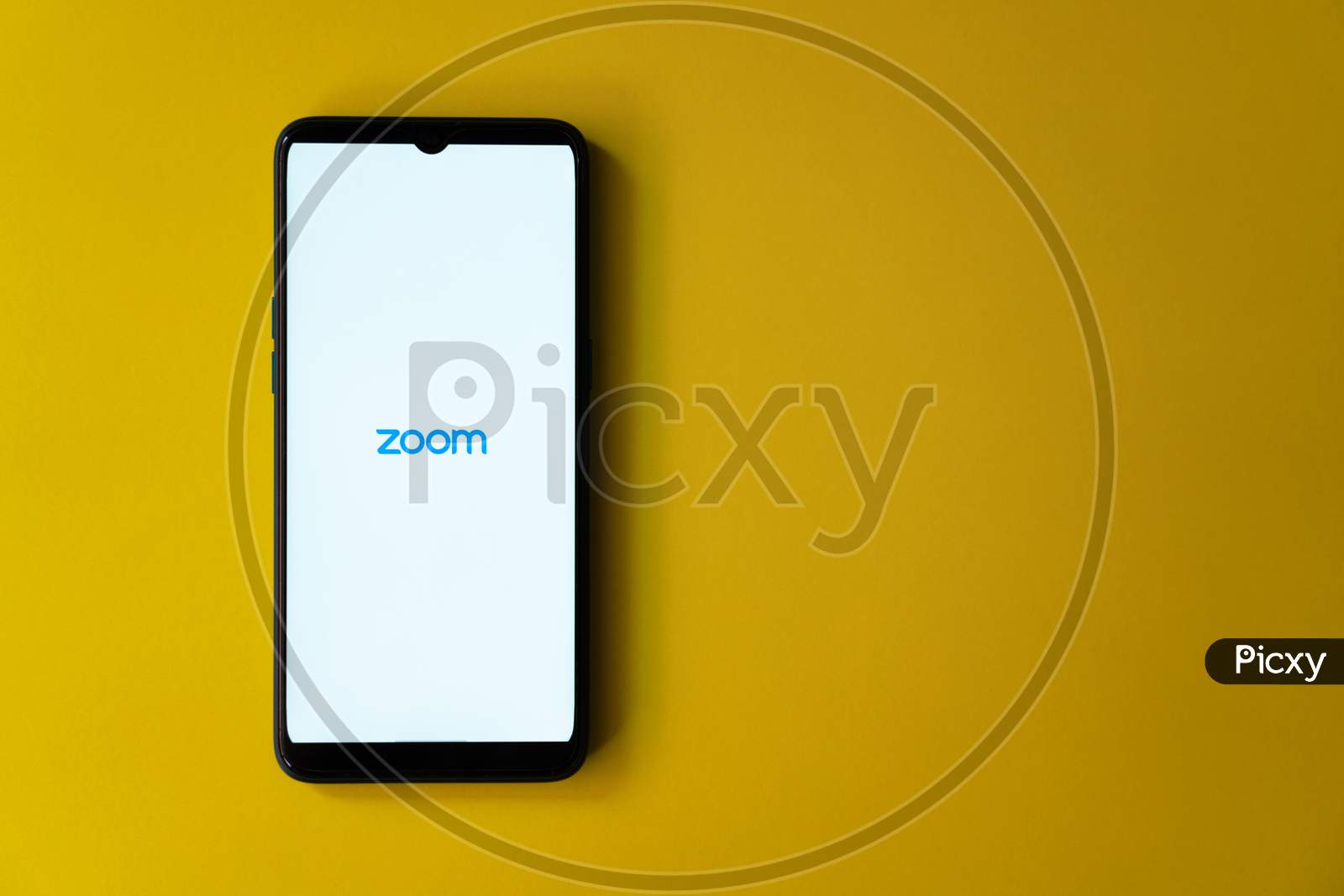 Zoom app home page on a smart phone against yellow background with copy space