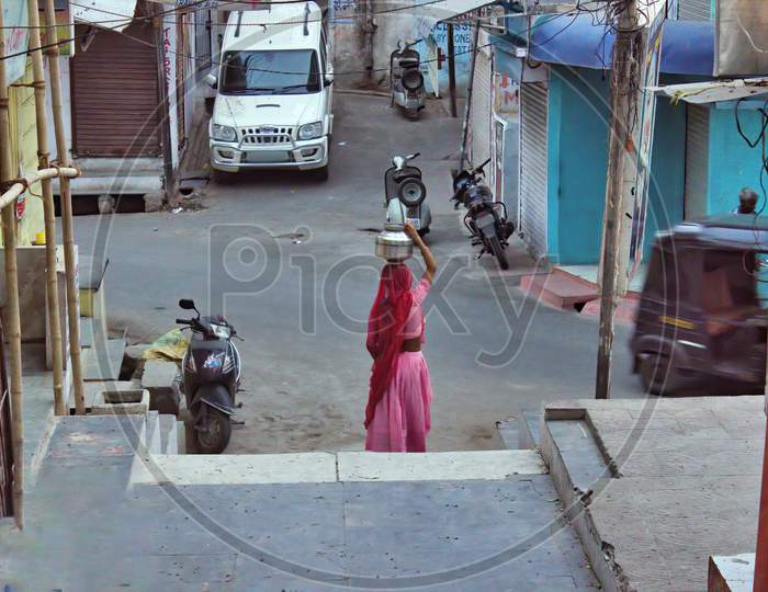 A Woman Carrying Ghada ( Jar ) Of Water On Head In Udaipur ( The City Of Lake ) Located In Rajasthan State, India