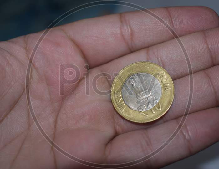 Ten rupees coin in hand