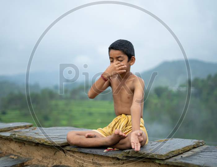 A Young Indian Cute Kid Doing Yoga In The Mountains,Wearing A Dhoti, Anulom Vilom