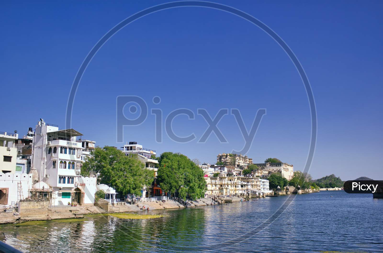 Indian Houses Next To A Lake Located In Udaipur City In Rajasthan State, India