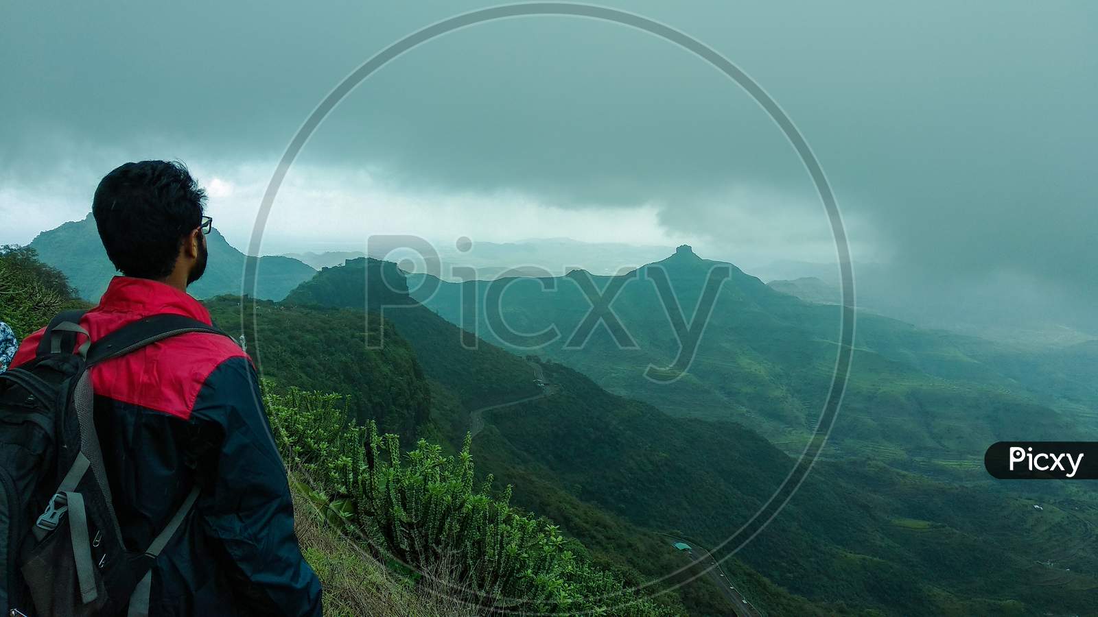 Side-Backward Photograph Of A Man Looking At A Distant Mountain Peak On A Trek In Purandar, Maharashtra, India