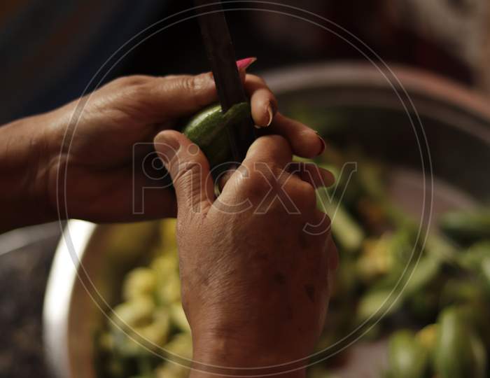 Indian Mother Cutting Green Vegetables With Sharp Edge Knife