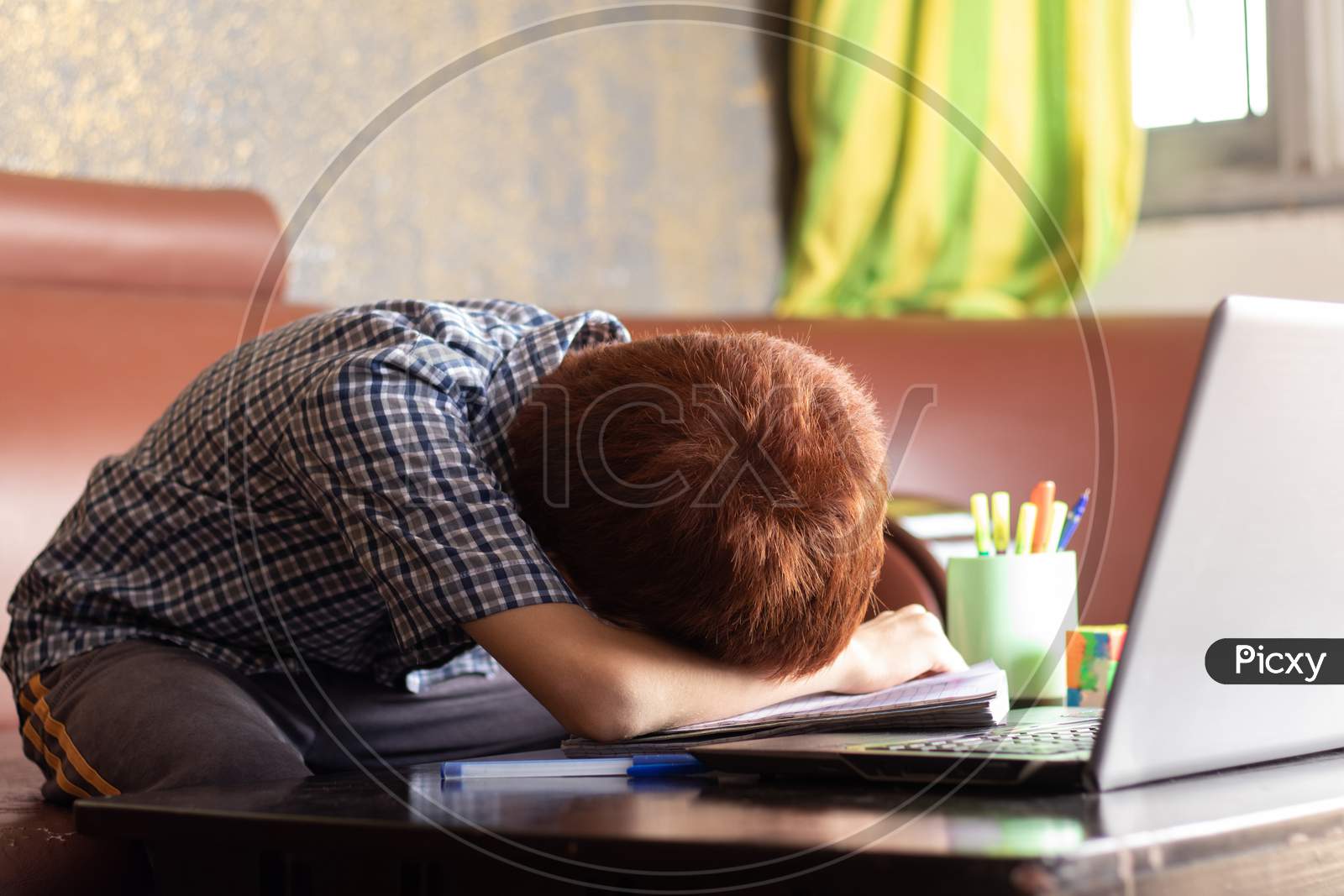 Bored Kid Slept Infront Of Laptop During Remote Learning - Concept Of Kid Tired From E-Learning Or Online Education At Home During Covid-19 Or Coronavirus Outbreak.