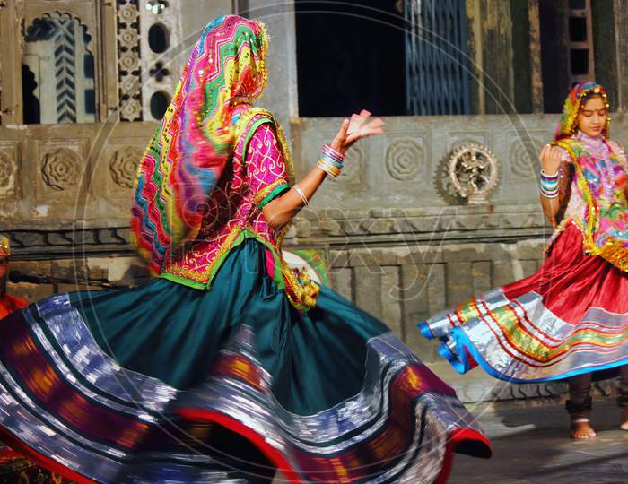 Udaipur, India - May 24, 2013: Two Indian Women Dancing In Rajasthan State Of India In Traditional Colorful Dress