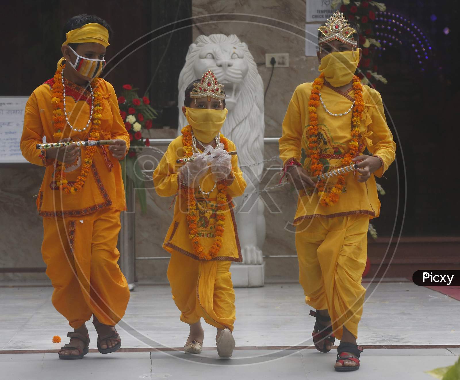 Children wear mask and gloves, dressed as Hindu Lord Krishna arrive at a temple  during Janmashtami celebrations, in Chandigarh August 11, 2020