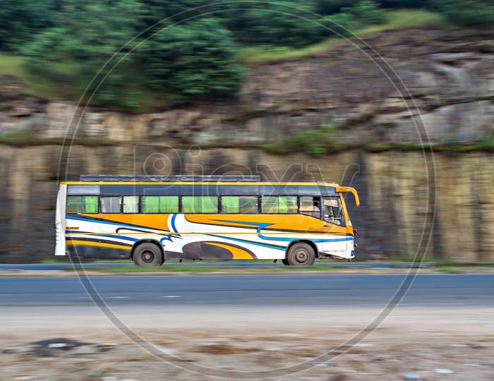 Panning Photo Of An Yellow Striped Non-Ac Private Travels Bus , Speeding Towards Mumbai.