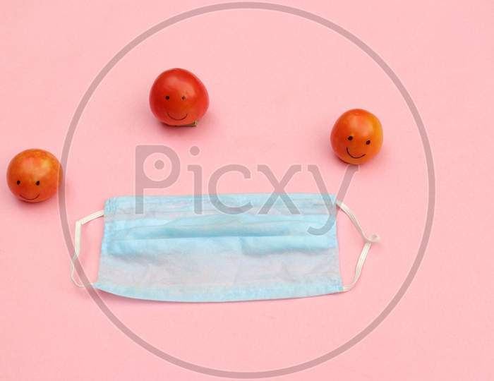 Social Distancing or Safe Distance Due to Coronavirus Conceptual Photo with Medical or Surgical Face Mask and Tomato Made Characters