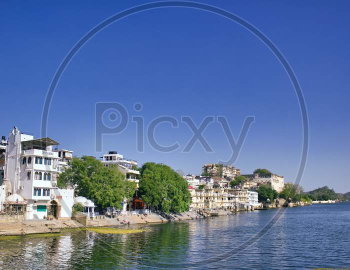Indian Houses Next To A Lake Located In Udaipur City In Rajasthan State, India