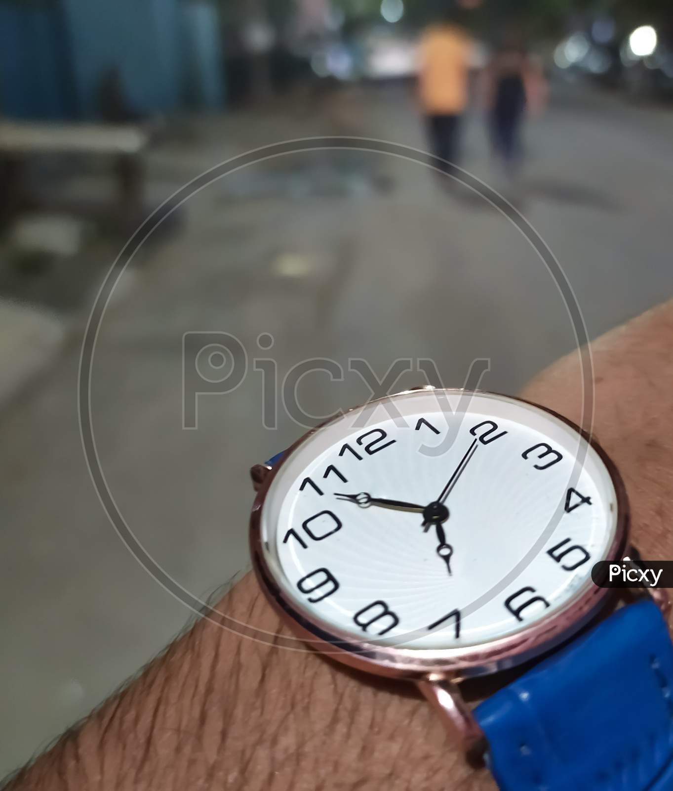Checking time in wrist watch at almost seven in evening