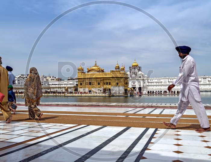 Amritsar,Punjab,India-April 15Th, 2019:Pilgrims Marching To Make A Clockwise Circumambulation Around The Pool Before Entering The Sanctum At Goden Temple(Harmandir Sahib).