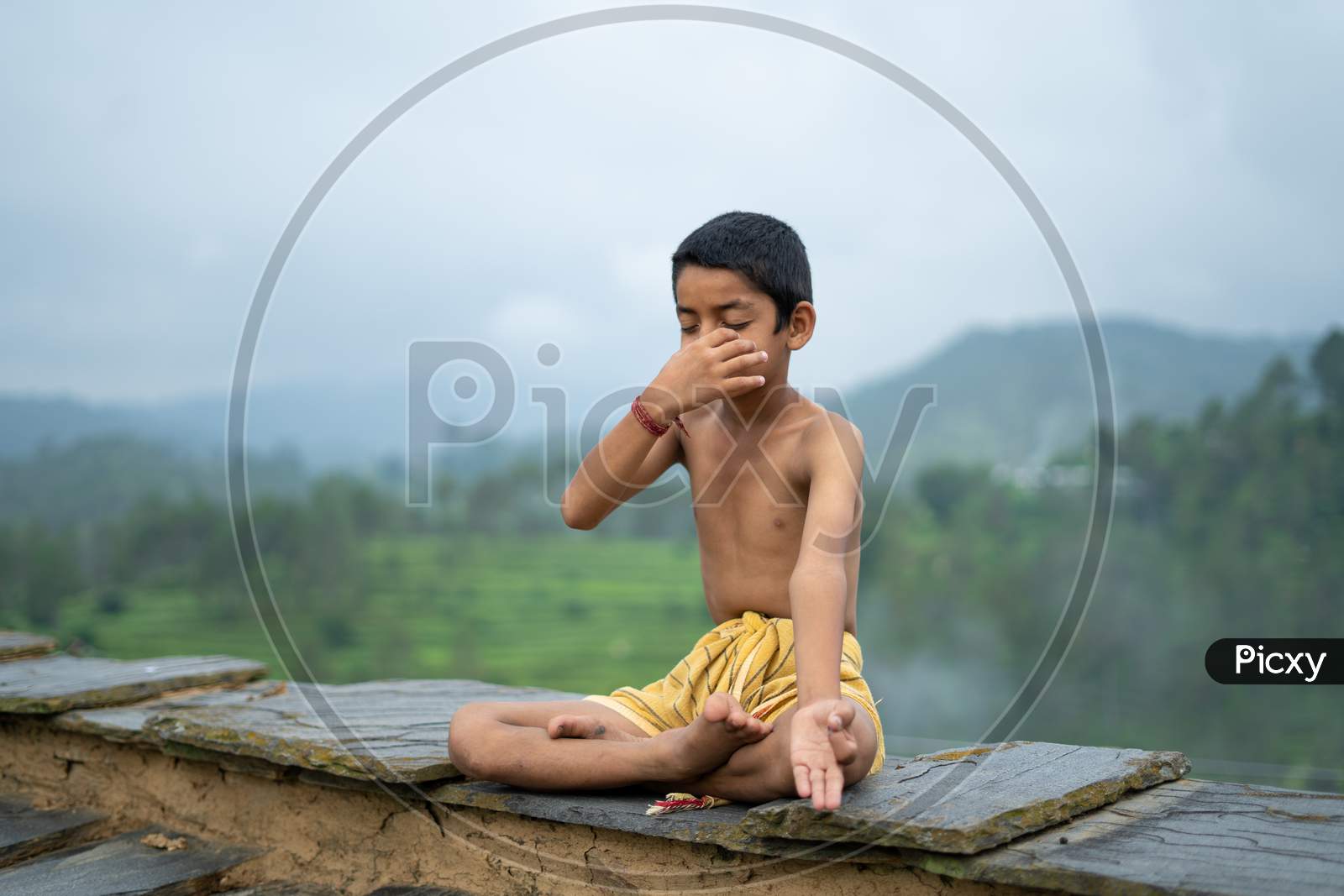 A Young Indian Cute Kid Doing Yoga In The Mountains,Wearing A Dhoti, Anulom Vilom