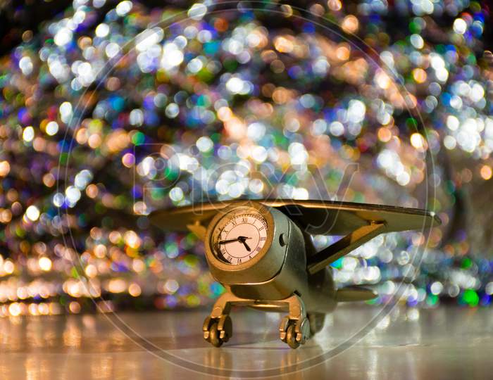 A Small Showpiece Containing A Clock On A Bokeh Background