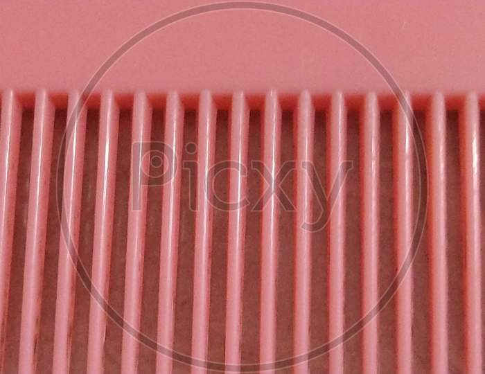 Pink plastic comb teeth texture.