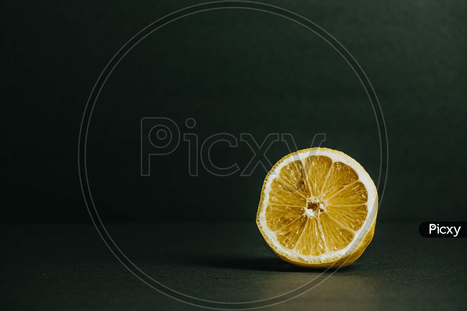 Half Of A Lemon With A Dark Green Background
